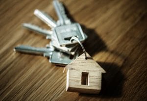 A set of keys with a wooden house on them