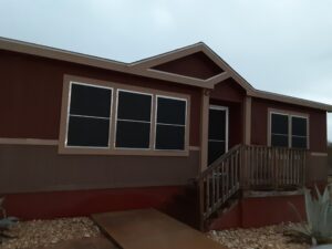 A burgundy colored mobile home with tan trim