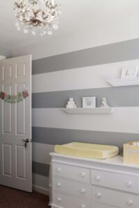 A bedroom with gray and white stripes on the wall