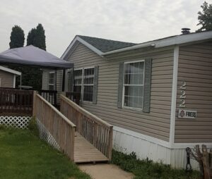 A doublewide mobile home with a wheelchair ramp