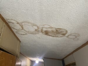 A ceiling with wet spots on it from the roof leaking