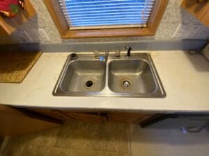 A metal sink in a kitchen countertop