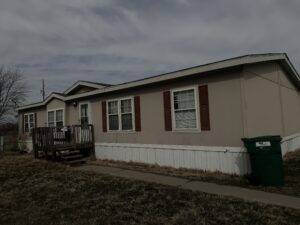 A doublewide mobile home that is sitting in a park