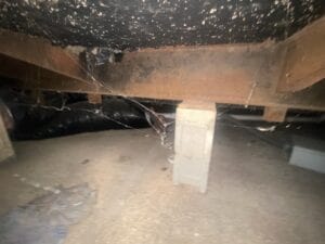 The underneath of a mobile home with a metal beam