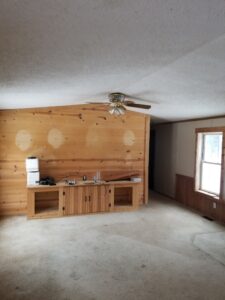 A mobile home living room with wood style mobile home paneling