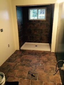 A new shower unit that is tiled and a tile floor