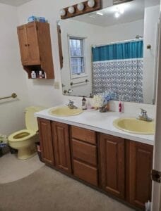A double sink that is yellow and a yellow toilet