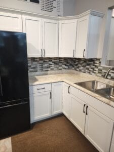A white kitchen with brick backsplash