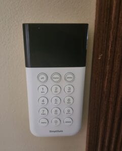 A simplisafe key pad on a wall
