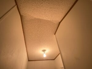 A popcorn ceiling in a hallway that needs repairs