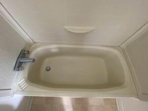 A tub with black stains in the bottom of it