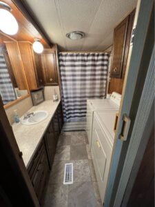 The laundry and bathroom area of a singlewide mobile home