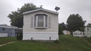 A singlewide mobile home in a park near other homes