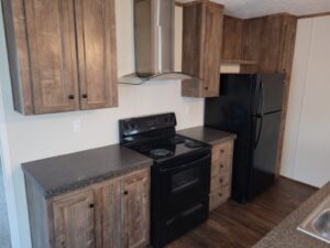 Brown wooded kitchen cabinets with a black stove