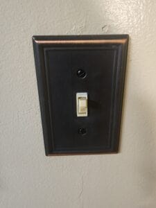 A light switch with a bronze metal cover