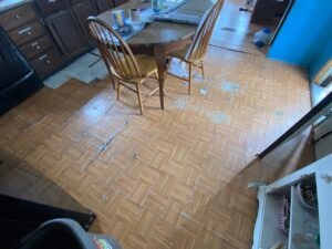 A torn up tile floor in a kitchen area
