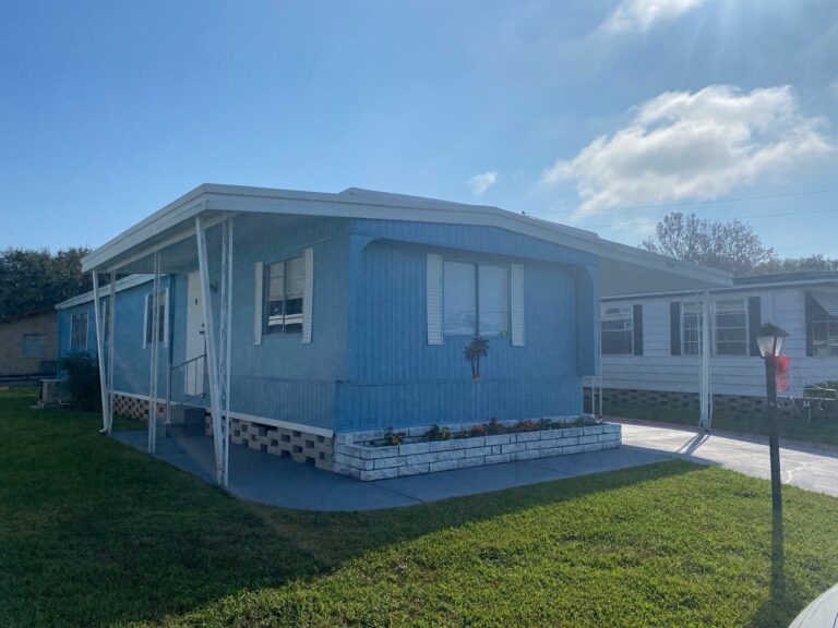An older mobile home in Florida with a carport drive