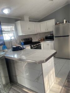 A new white kitchen in a mobile home with shiny countertops