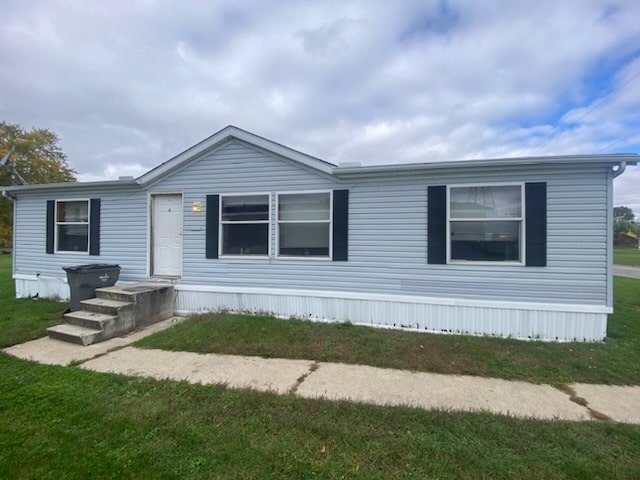 A blue doublewide with black shutters and a concrete walk out front