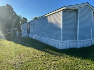 A blue singlewide with a shadow on it from a nearby tree