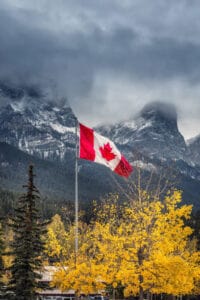 A canadian flag with mountains in the background