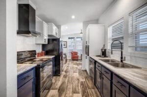 A kitchen to a tiny home with wood floors