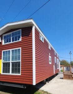 A double story tiny home with red siding