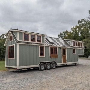 A pea green mobile home on wheels ready to move