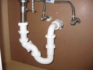 white plumbing pipe under a sink