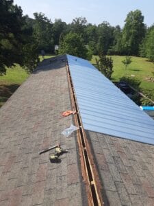 One side of a roof with metal over the shingles being installed