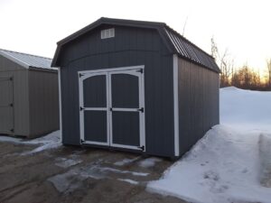 A gray shed with white trim