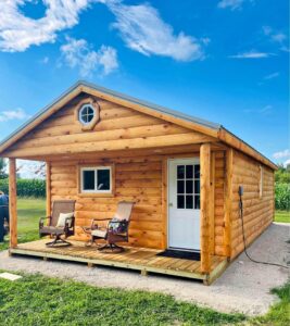 A cedar type shed with a porch for sitting