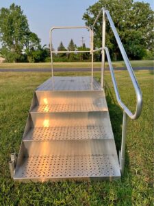 A portable metal deck with grates on the steps