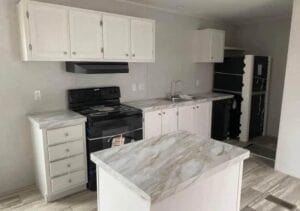 A white kitchen with a marble countertop