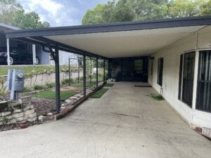An attached carport with a cement floor