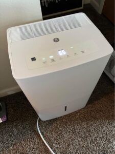 A white colored dehumidifier sitting on a floor