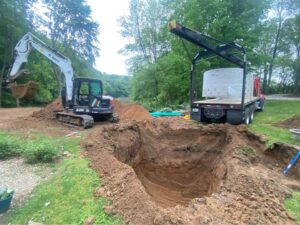 2 excavators digging a hole for a new septic tank