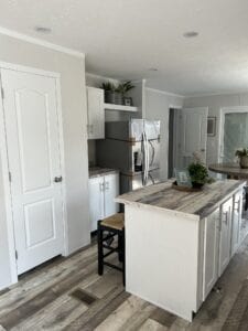 A white kitchen with a white island