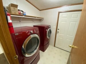 A red washer and dryer sitting in a laundry room
