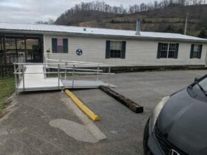 A mobile home on a paved lot with a mountain in the background