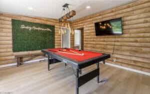 A pool table in a room with log walls