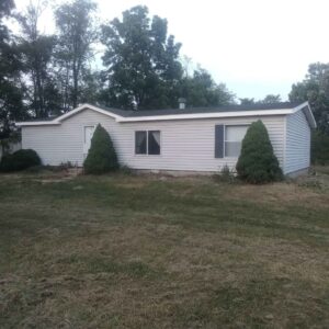 A doublewide on private land with a large pine out front