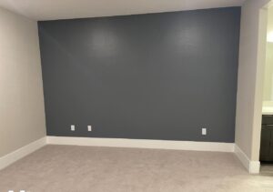 A newly painted gray wall with white trim