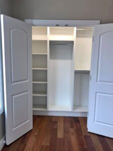 a large white closet with double doors
