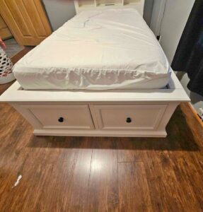 A bed with a drawer set under it