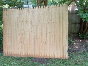 A wooden picket privacy fence
