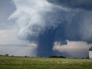 A very large tornado coming across a field