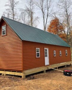 A large log sided mobile home on a wood foundation