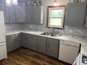 A gray kitchen with cupboards and backsplash
