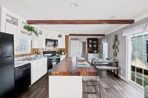 A kitchen that has white cupboards and wood floors